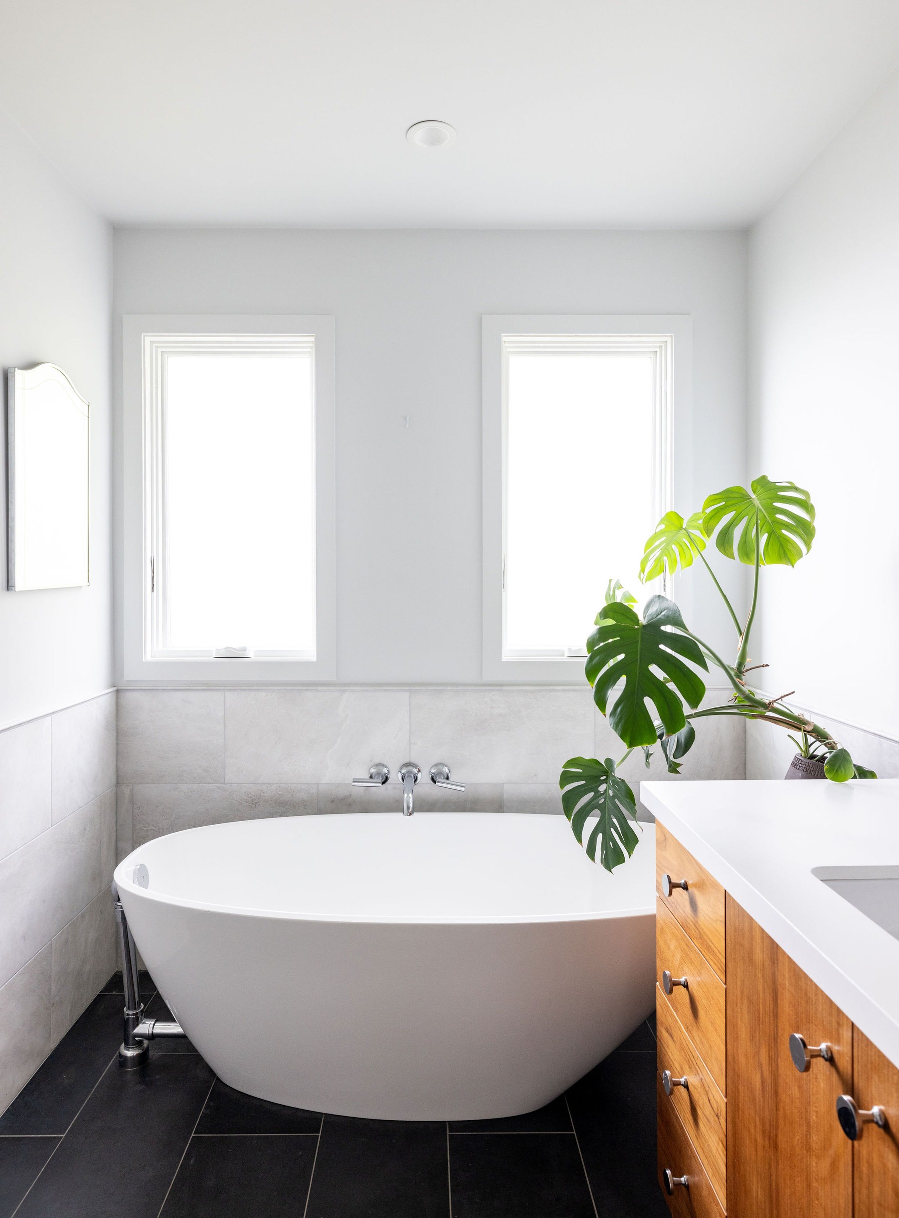 Freestanding soaking tub with monstera plant by Build Shepherd