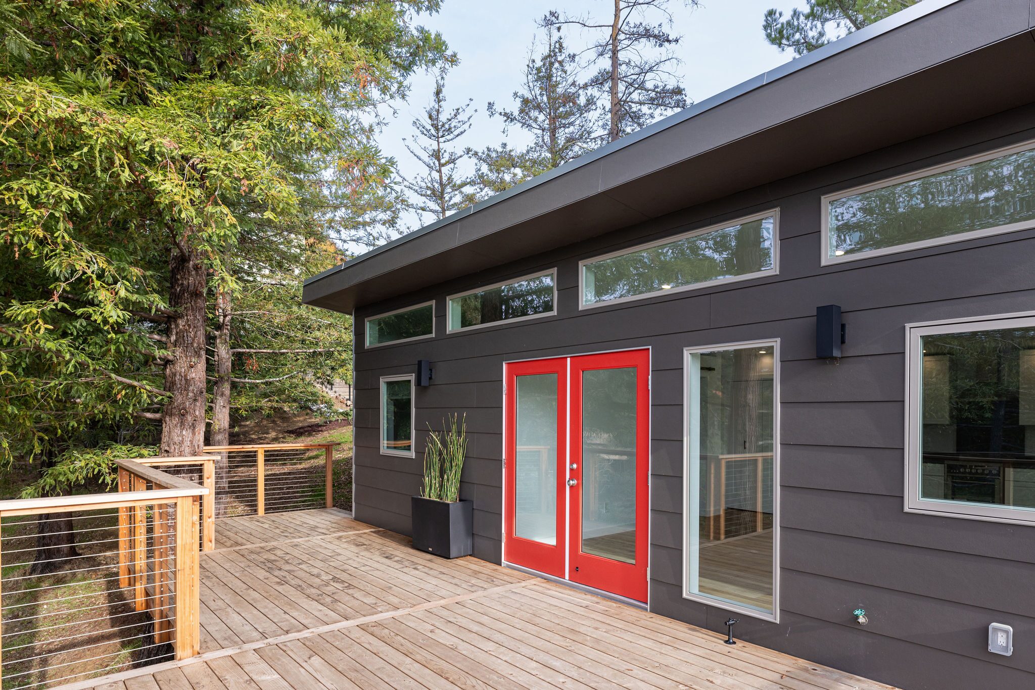 Custom backyard ADU studio with deck and modern exterior by Build Shepherd