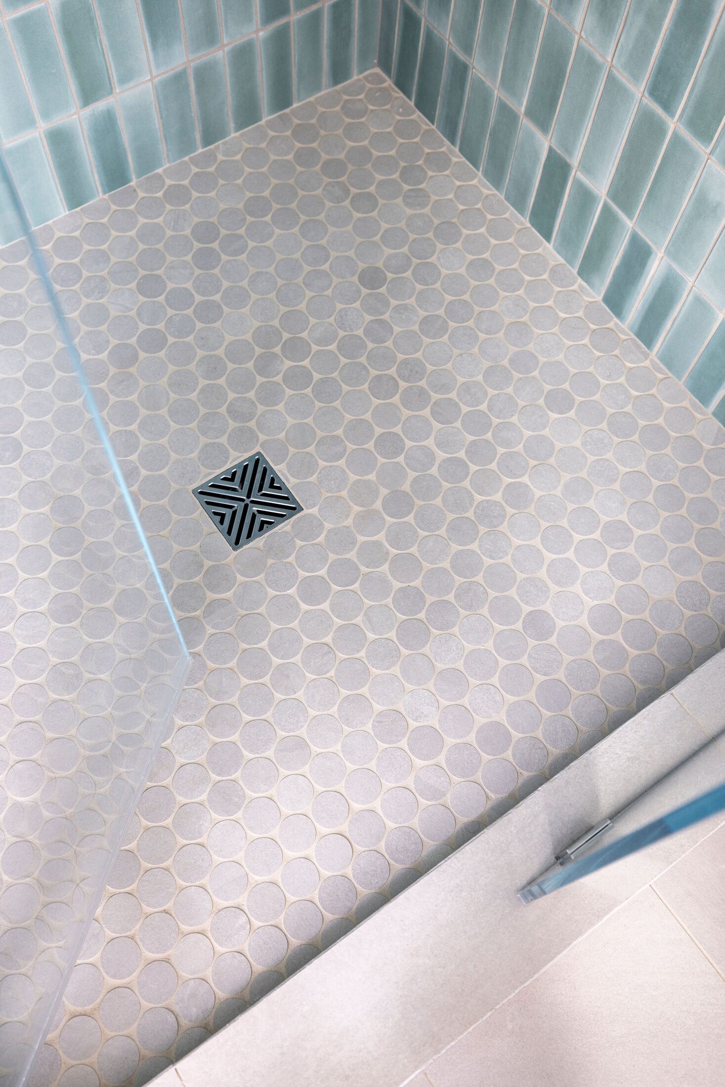 Detail of hand-glazed teal shower tile and penny-tile floor by Build Shepherd
