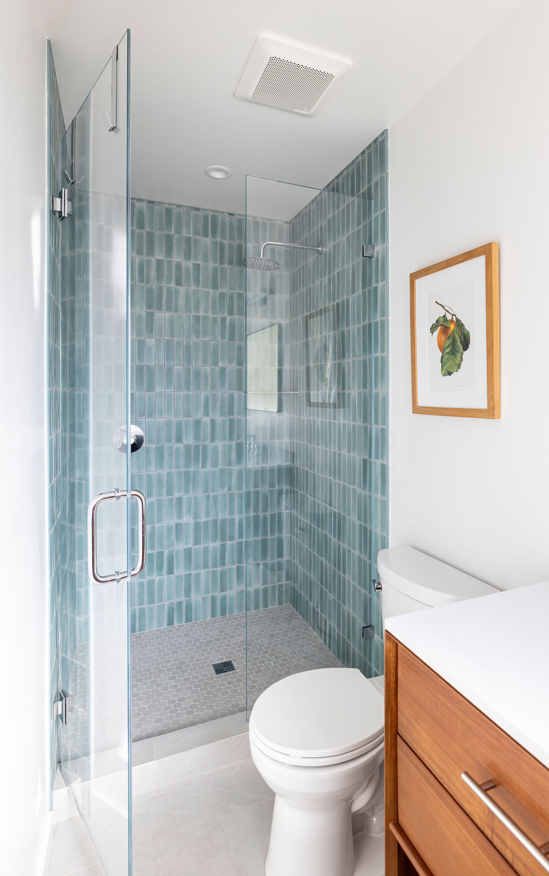 Guest bathroom after remodel — green tile walk-in shower and walnut vanity