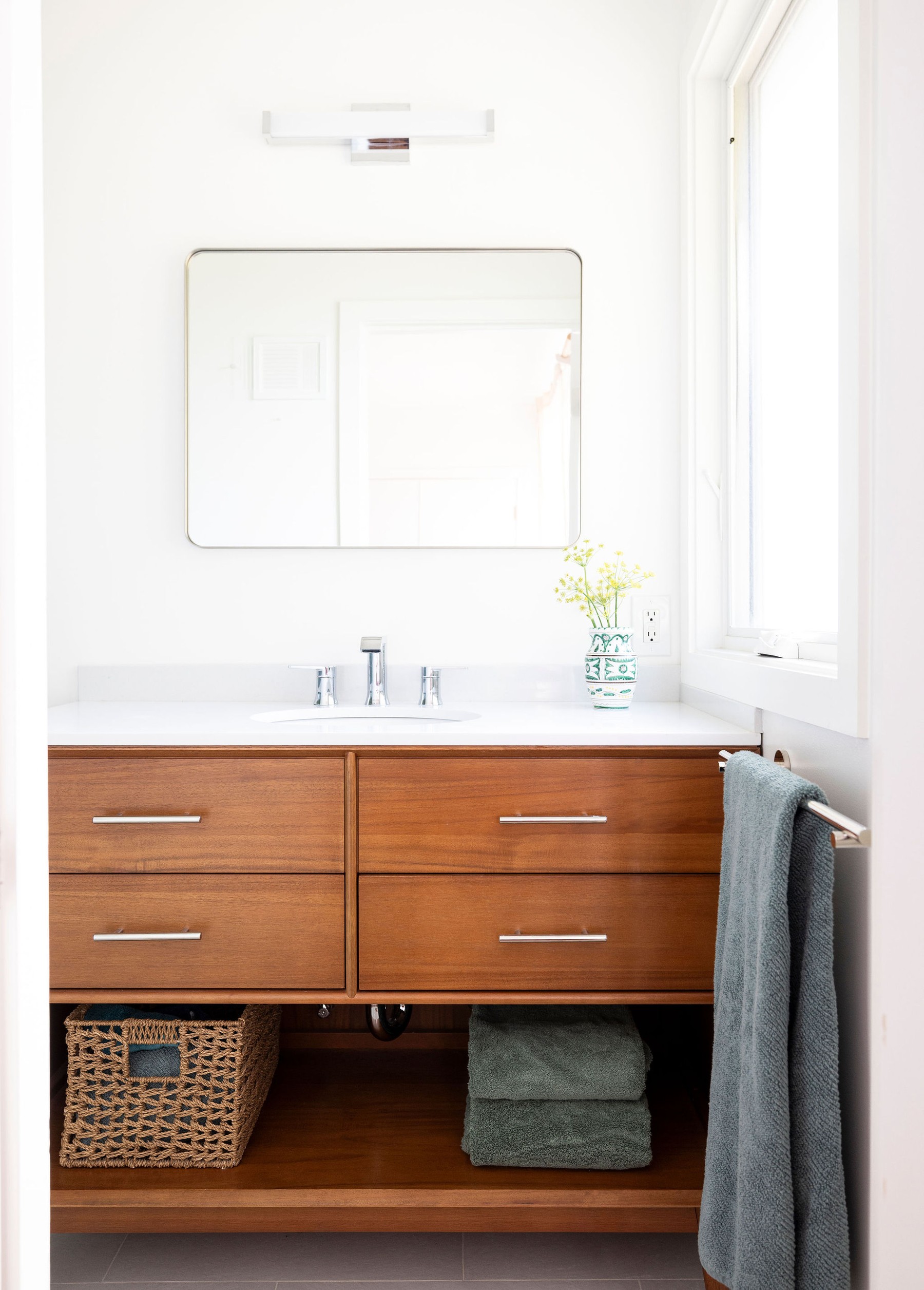 Guest bathroom after remodel — detail of vanity and woven storage